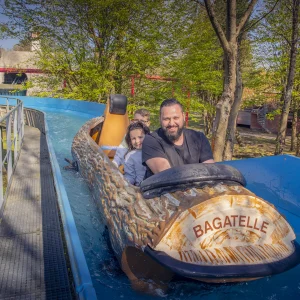 Reportage photo au parc Bagatelle - passagers souriants sur le flume Bagatelle, moment convivial en famille