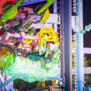 Reportage photo à la Feria de Séville Ala Delta - prise de vue nocturne des néons et jeux de lumières autour du gliding coaster Ala Delta