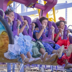 Reportage photo à la Feria de Séville Ala Delta - zoom sur les visages heureux des passagers sur le gliding coaster