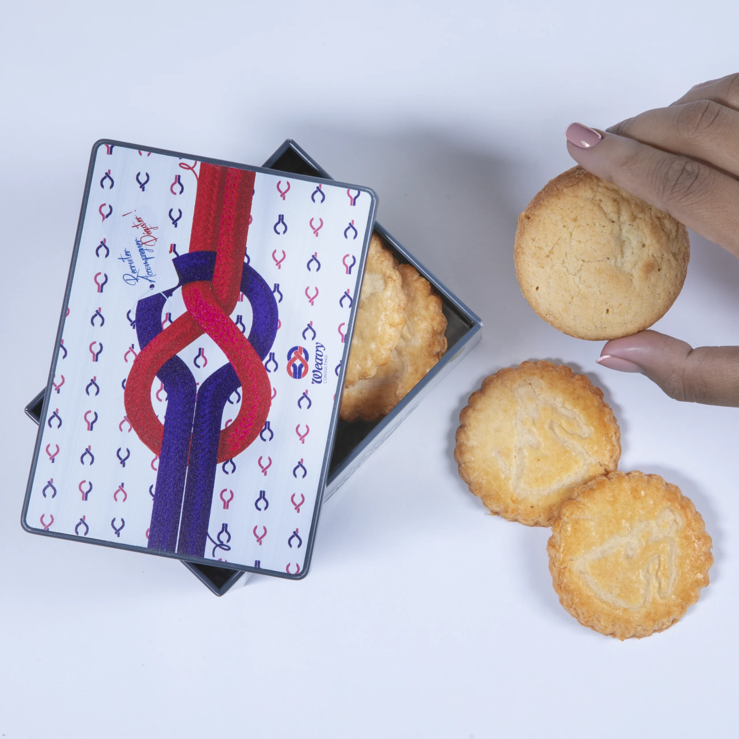 Weavy boîte à biscuits main qui attrape un biscuit Photo Weavy boîte à biscuits - mise en scène d'une main attrapant un biscuit de la boîte