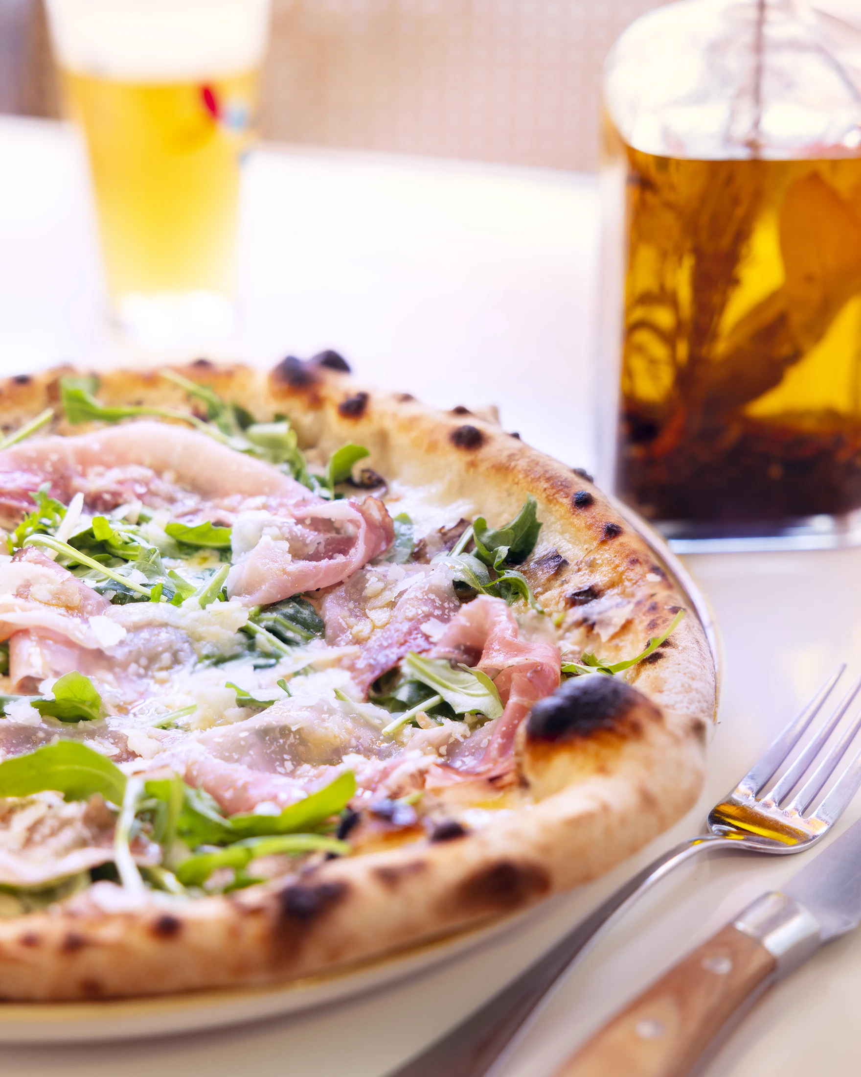 Shooting Photo - Photographie culinaire d'une pizza accompagnée de sa sauce piquante sur une table de l'Impasto par l'Agence Verveine